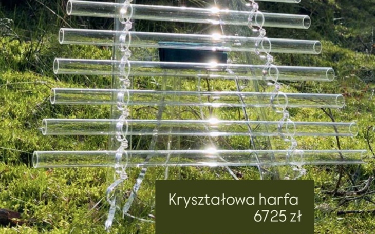 Kryształowa harfa na tle zielonej trawy, z ceną.