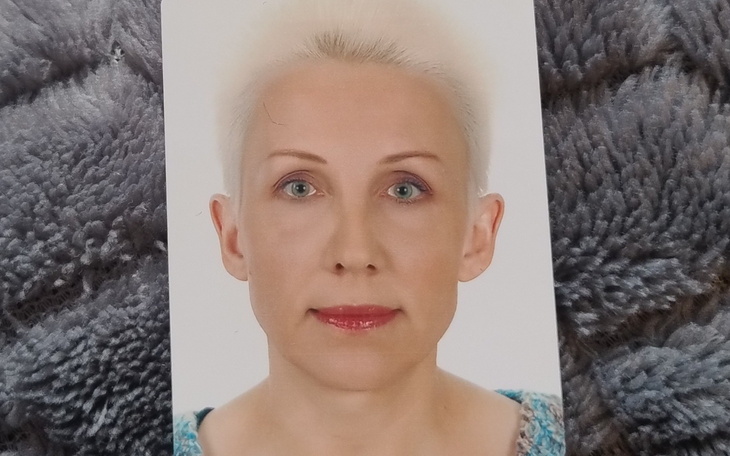 Zdjęcie kobiety z krótkimi włosami, patrzącej w obiektyw.