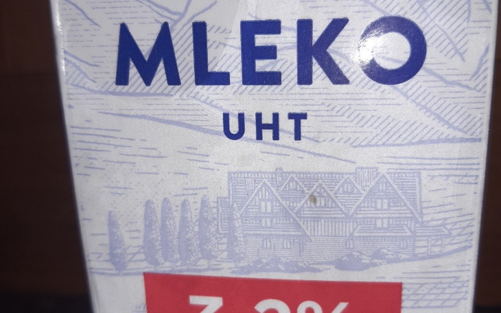 Opakowanie mleka UHT z widoczną grafiką i informacją o zawartości tłuszczu.