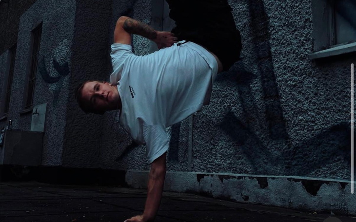 Młody mężczyzna wykonujący akrobacje na ulicy.