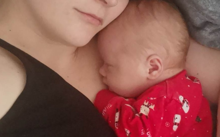 Matka z dzieckiem śpiącym na jej piersi.