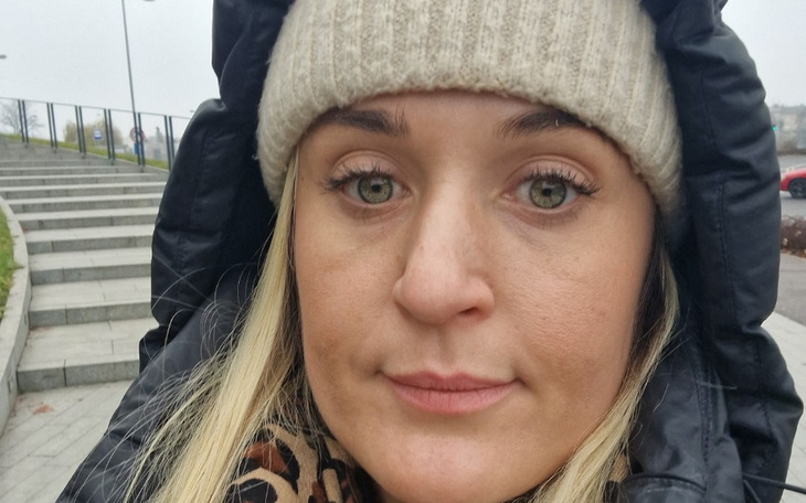 Portret kobiety w ciepłej czapce na tle schodów.