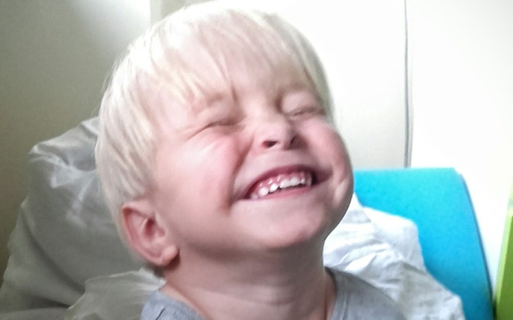 Mały chłopiec z szerokim uśmiechem na twarzy.