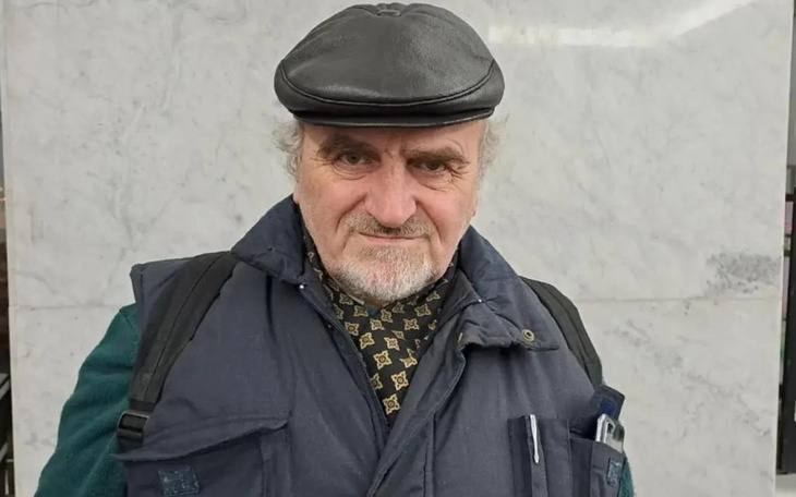 Mężczyzna w czapce, uśmiechający się do kamery.