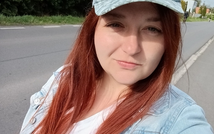 Młoda kobieta w czapce, uśmiechająca się do kamery.