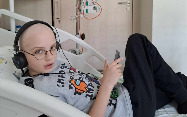 Chłopiec w szpitalu, słuchający muzyki na telefonie.