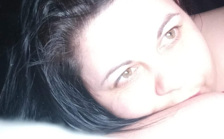 Kobieta leżąca na boku, z wyrazem zamyślenia.