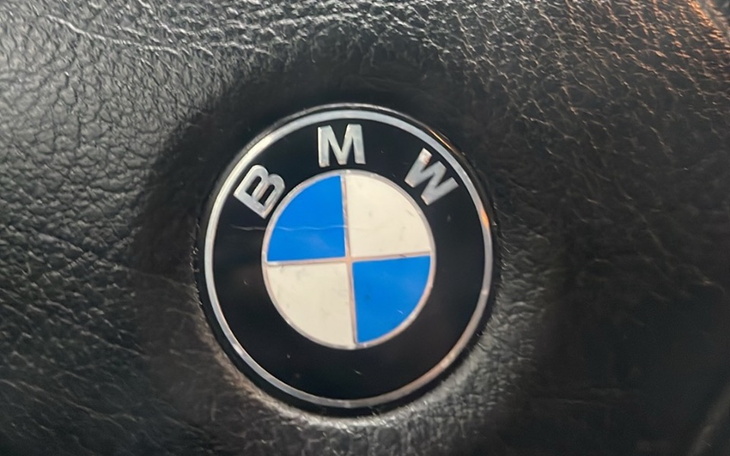 Logo BMW na czarnej skórzanej tapicerce.