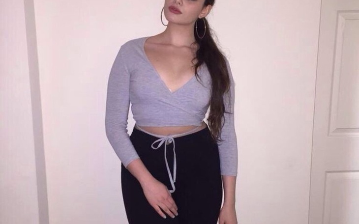 Młoda kobieta w modnej stylizacji, pozująca na tle ściany.