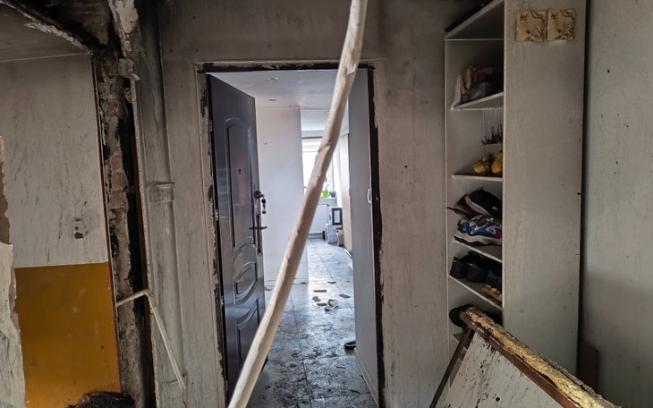 Widok na wnętrze mieszkania z otwartymi drzwiami.