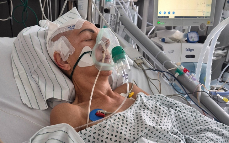 Osoba w szpitalu z maską tlenową na twarzy.