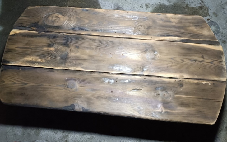 Drewniany stół z widocznymi słojami i naturalnym wykończeniem.