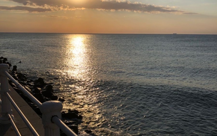 Zachód słońca nad morzem, refleksy na wodzie, spokojny widok.