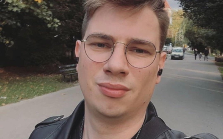 Mężczyzna robiący selfie na ulicy, z okularami i uśmiechem.