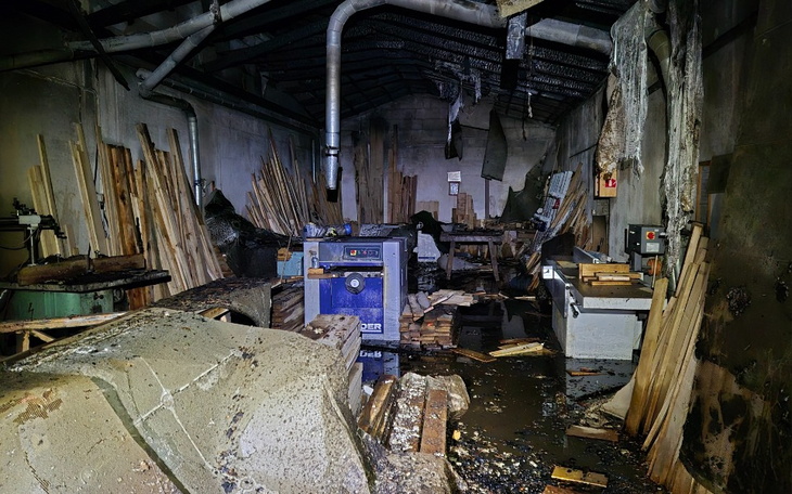 Zniszczona przestrzeń robocza z drewnem i sprzętem.