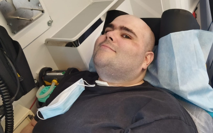 Mężczyzna w karetce, uśmiecha się do kamery.