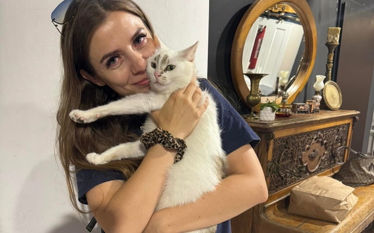Kobieta przytulająca białego kota.