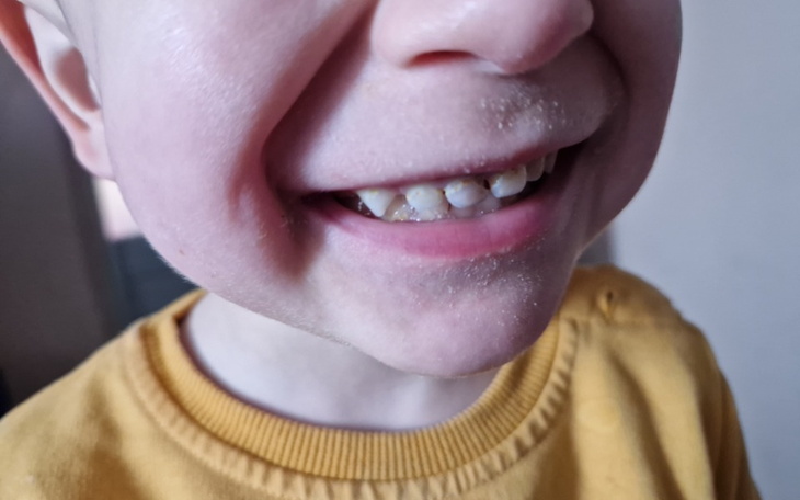 Czarny pies leżący na podłodze w pomieszczeniu.