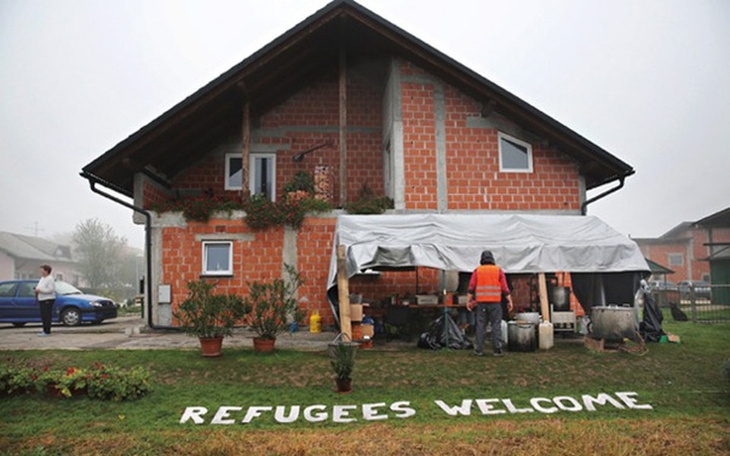 Dom z napisem 'Refugees Welcome', przyjazna atmosfera.