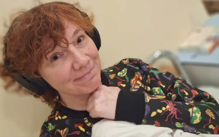 Uśmiechnięta kobieta w kolorowej bluzie.