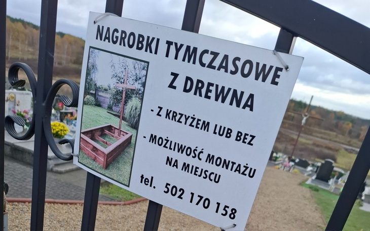 Tablica informacyjna o nagrobkach tymczasowych na cmentarzu.