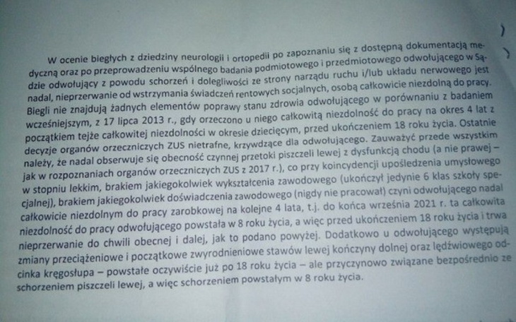 Dziecko bawiące się na trawie, uśmiechnięte i w kapeluszu.