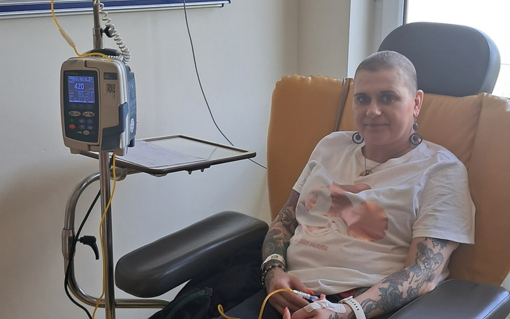 Kobieta w szpitalu, podłączona do kroplówki, z tatuażami.