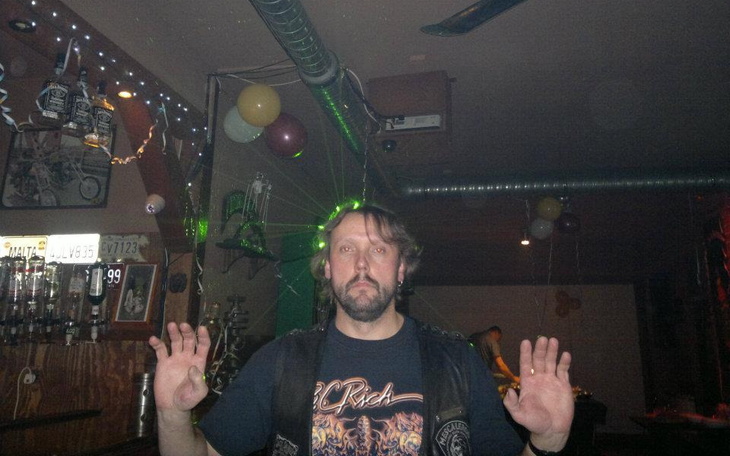 Mężczyzna w klubie, z rękami uniesionymi w górę.