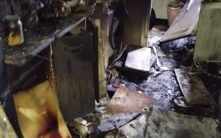 Zniszczona kuchnia po pożarze, widoczne popioły i zniszczenia.
