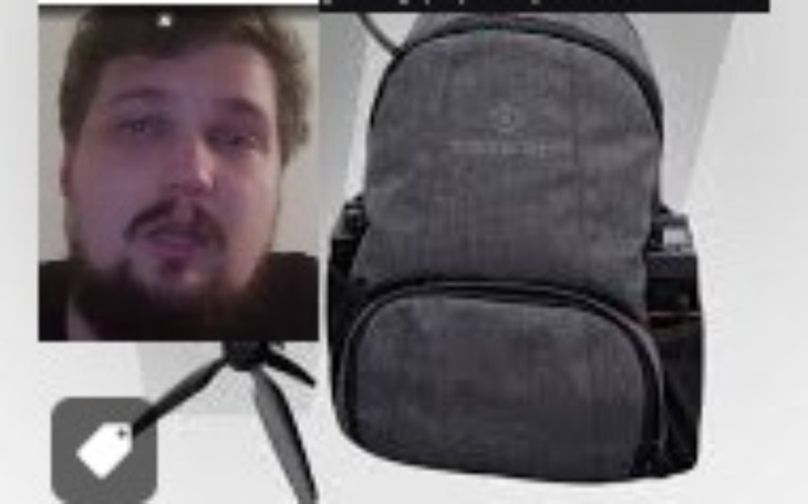 Mężczyzna z plecakiem, w tle sprzęt elektroniczny.