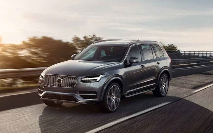 Nowoczesny SUV w ruchu, na tle zachodzącego słońca.