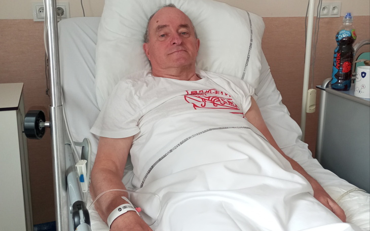 Zdjęcie osoby chorej w łóżku, ciepłe światło w pomieszczeniu.