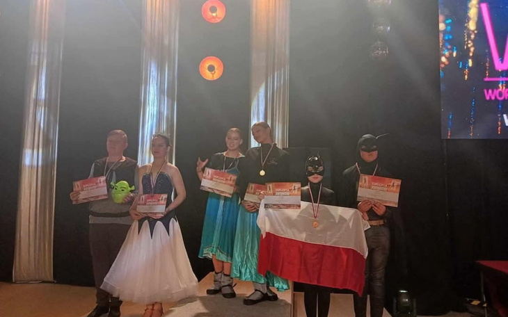 Uczestnicy konkursu w strojach, z medalami i dyplomami.