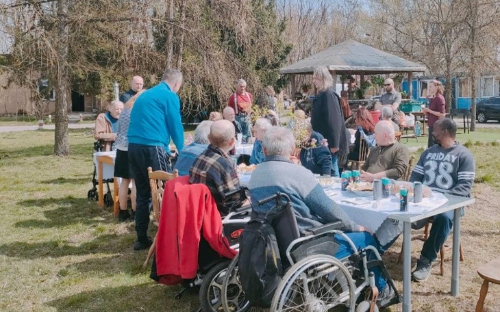 Spotkanie ludzi przy stole na świeżym powietrzu.