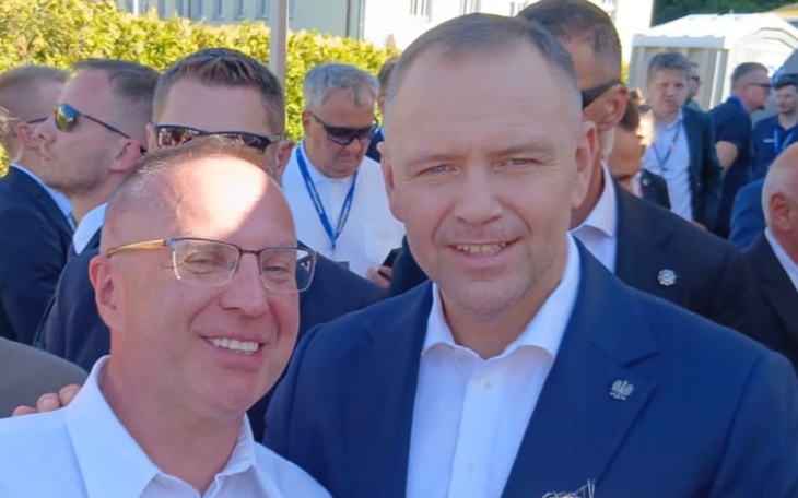 Dwóch mężczyzn na zewnątrz, uśmiechnięci podczas spotkania