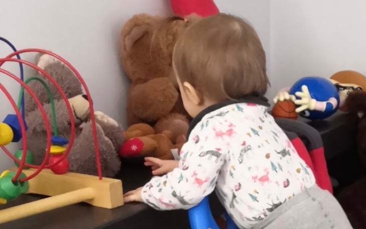 Małe dziecko bawi się przy zabawkach.