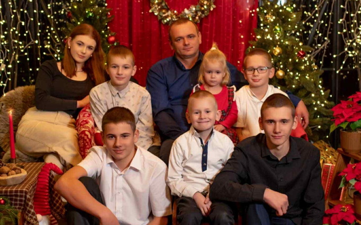 Rodzina pozująca na tle świątecznej dekoracji.