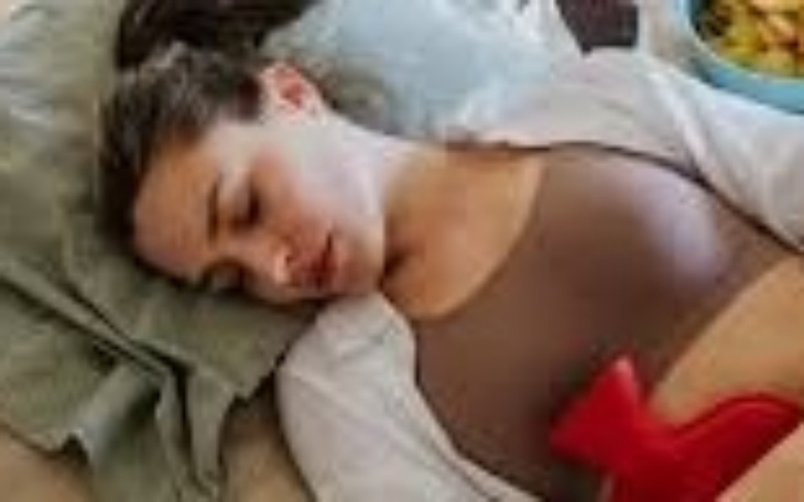 Kobieta leżąca na podłodze z czerwonym przedmiotem na brzuchu.