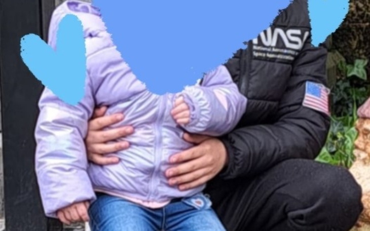 Dziecko w ramionach opiekuna, radosny uśmiech.