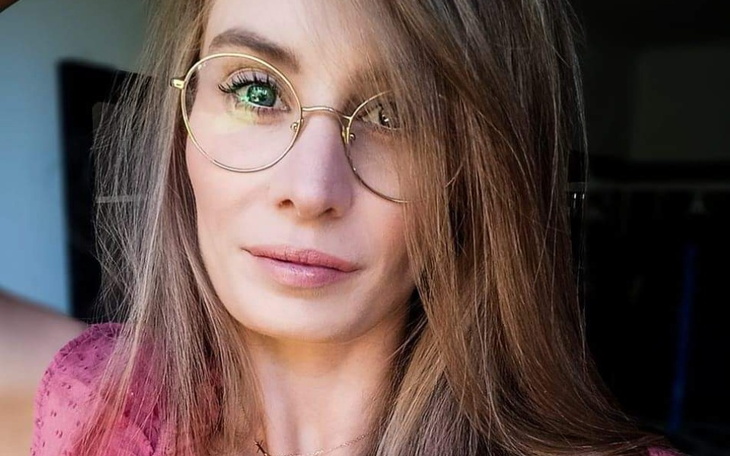 Kobieta w okularach, uśmiechająca się do kamery.