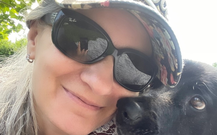 Kobieta z okularami przeciwsłonecznymi i psem.