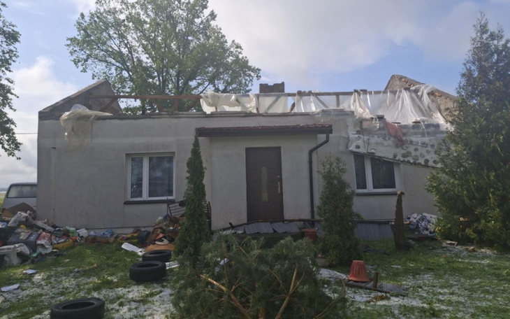 Zniszczony dom po burzy, z brakującym dachem i bałaganem.