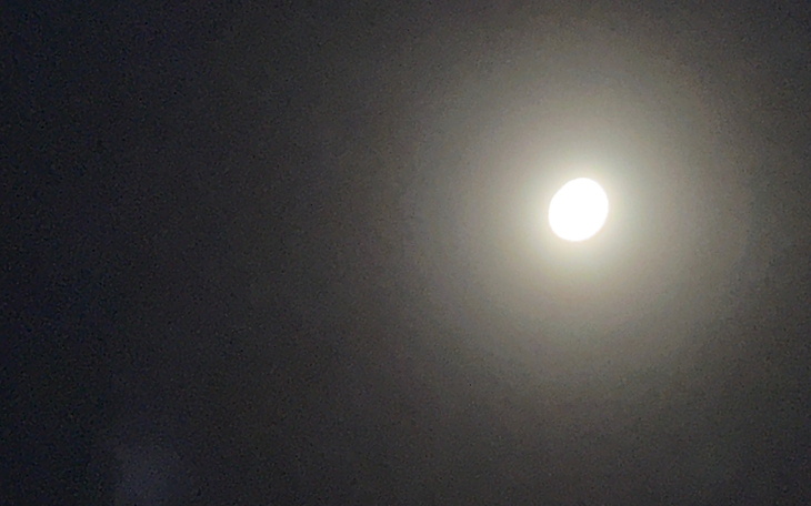 Księżyc w pełni świeci na nocnym niebie.