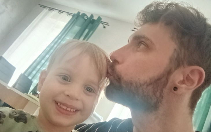 Mężczyzna całujący dziecko w policzek.