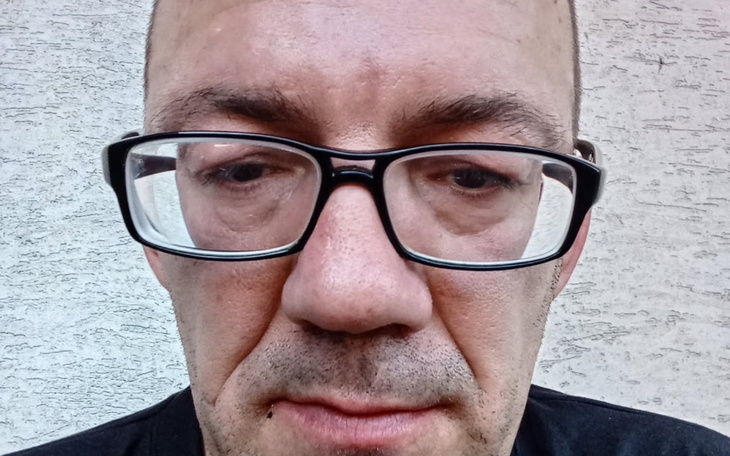 Mężczyzna z okularami, wyraz twarzy smutny.