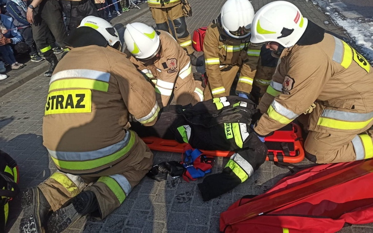 Strażacy udzielają pomocy poszkodowanemu na noszach.