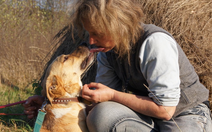 Kobieta przytulająca psa na świeżym powietrzu.