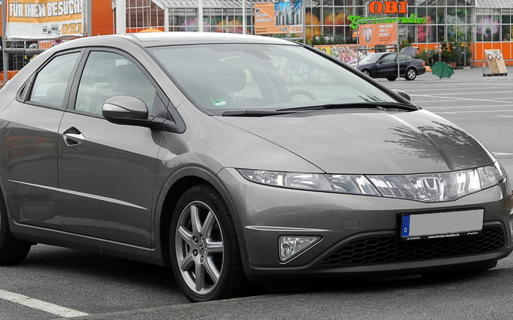 Szary samochód zaparkowany na parkingu.