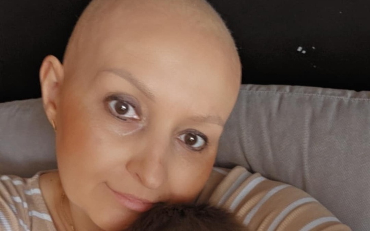 Kobieta z krótkimi włosami przytulająca dziecko.