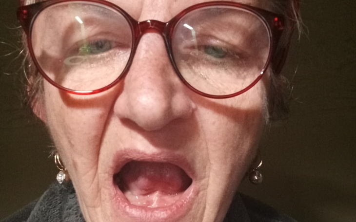 Starsza kobieta z otwartą buzią, wygląda na zaskoczoną.